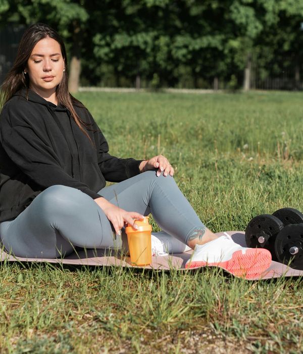 Person meditating peacefully after a light cardio workout, sitting on a mat.